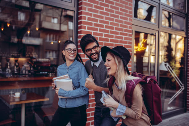Sharing laughs Cropped shot of three students laughing on the street group of people wearing eyeglasses stock pictures, royalty-free photos & images