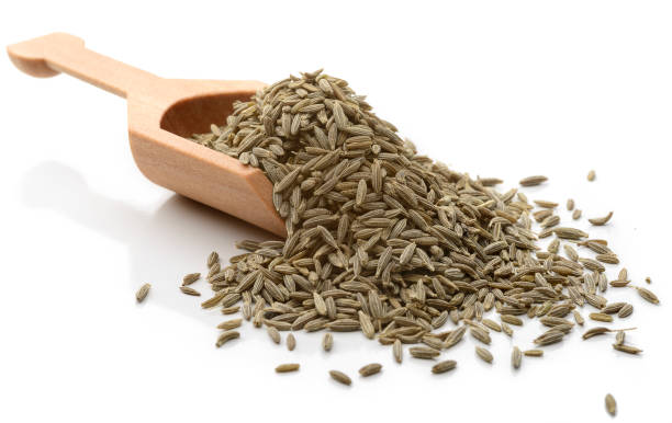 Cumin Scoop of cumin seeds. 
Isolated on white. caraway seed stock pictures, royalty-free photos & images