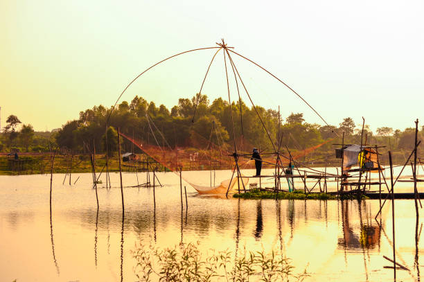 istock Fisherman fishing by using traditional bamboo fishing tools 935844058