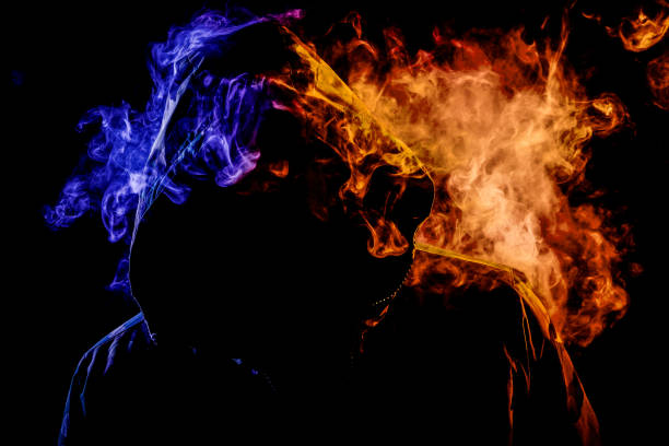 istock A young man in a black hood smokes 935844354