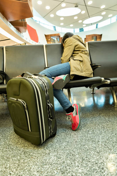 istock Young woman sleeping an airport terminal seat 935852490