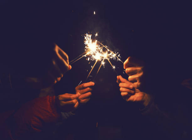 istock Picture showing group of hand having fun with sparklers. 935872172