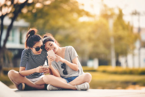 Two women friends sit in the park and relax on a happy holiday. stock photo