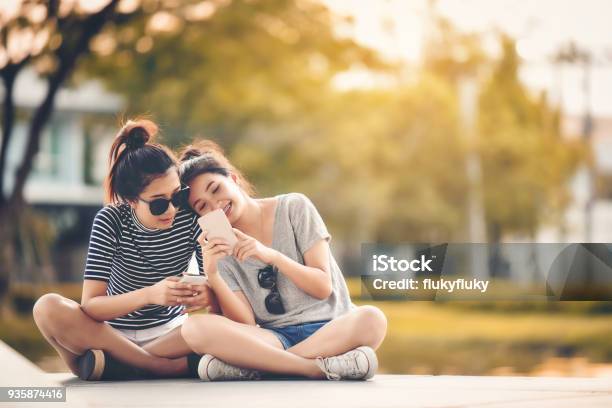 Two Women Friends Sit In The Park And Relax On A Happy Holiday Stock Photo - Download Image Now