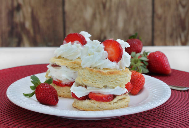istock Two Strawberry Shortcakes with whipped cream on a white plate.  Close up with copy space. 935877004