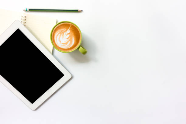 istock White office desk table with blank notebook, smart phone and cup of coffee.Top view with copy space. 935891954
