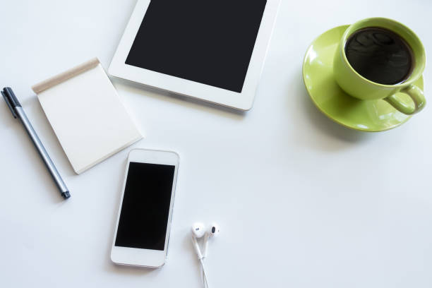 istock White office desk table with blank notebook, cup of coffee.Top view with copy space. 935902190