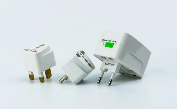 Photo of Set of universal plug adapters for travel around the world isolated on white background.