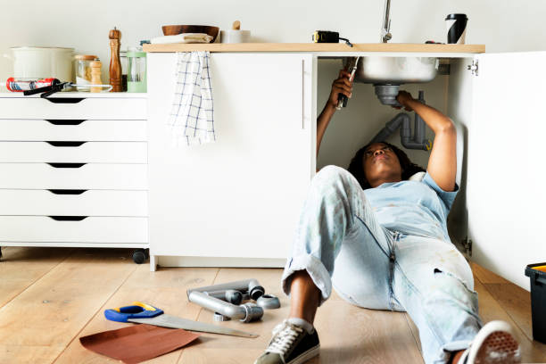 Woman fixing kitchen sink Woman fixing kitchen sink home ownership women stock pictures, royalty-free photos & images