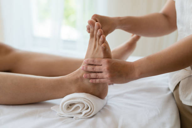 ragazza asiatica rilassante con massaggio ai piedi in un salone termale, vista ravvicinata - foot massage foto e immagini stock