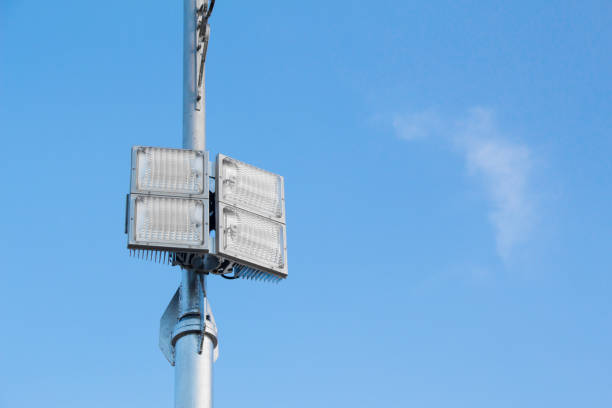 istock Silver lamp post with a light LED bulb on the left side and background sky. 935916556