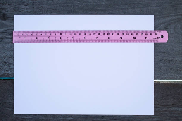 istock White paper with pink ruler on wood texture background 935918992