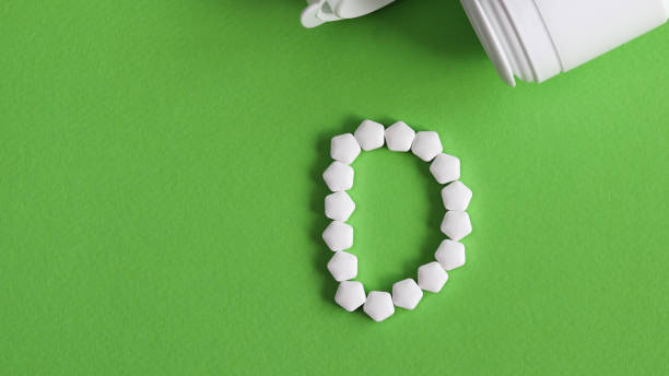 istock white pills forming shape to D alphabet on light green background 935919306