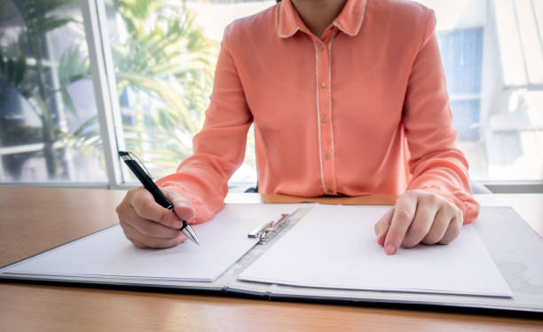 istock Business woman use laptop computer hand working with business document and using on the table 935924756