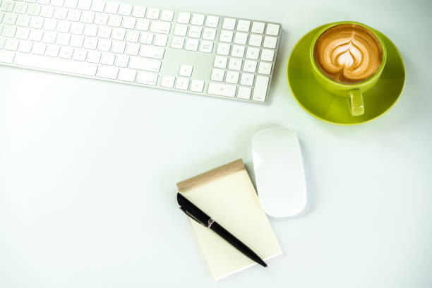 istock Modern White office desk table with pen and notebook,cup of coffee. Top view with copy space.Working desk table concept. 935926874