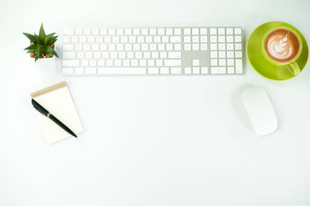 Modern White office desk table with pen and notebook,cup of coffee. Top view with copy space.Working desk table concept.