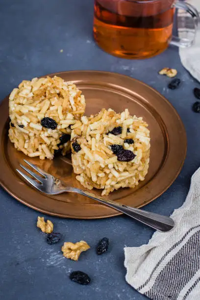 Photo of Eastern or Asian sweets (chak-chak) with honey, raisins and walnut on stone concrete table background