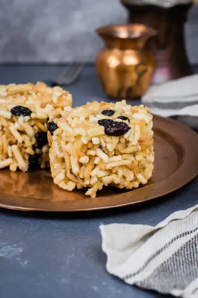 Photo of Eastern or Asian sweets (chak-chak) with honey, raisins and walnut on stone concrete table background