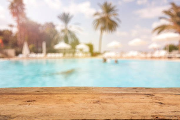Brown Wooden Table and Blurred Swimming Pool Brown Wooden Table and Blurred Swimming Pool beach bar stock pictures, royalty-free photos & images