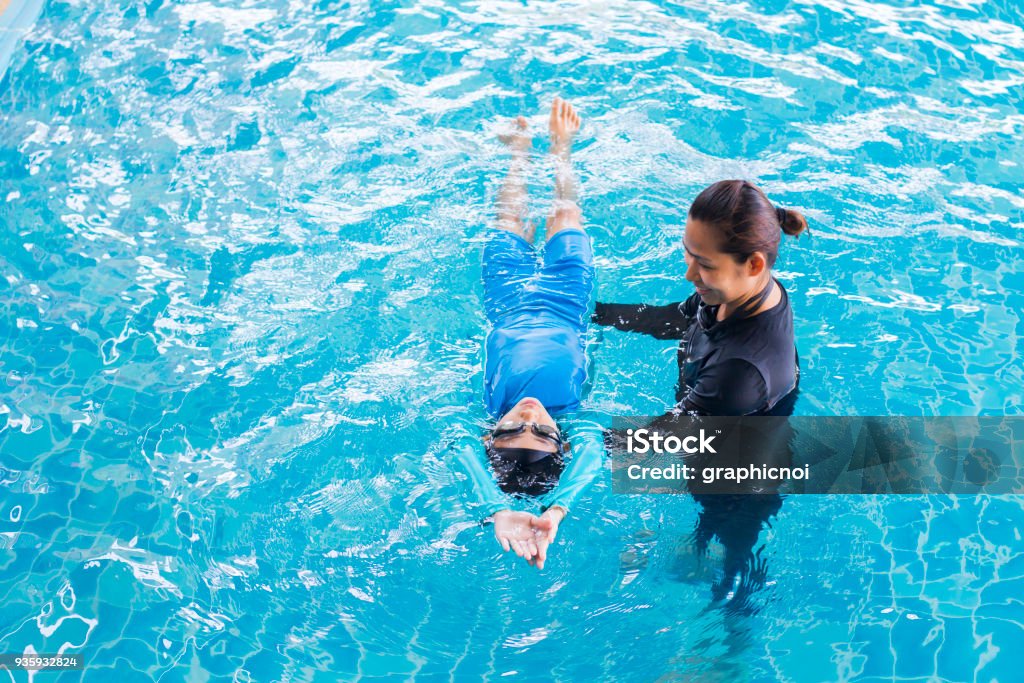 Fille, apprendre à nager avec l’entraîneur au centre de loisirs - Photo de Natation libre de droits