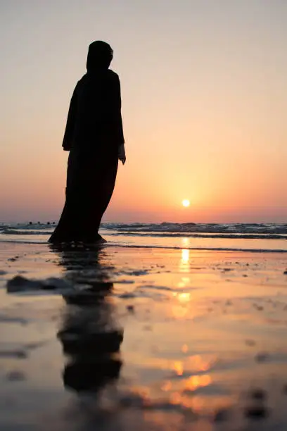 Photo of Woman in hijab standing on the beach