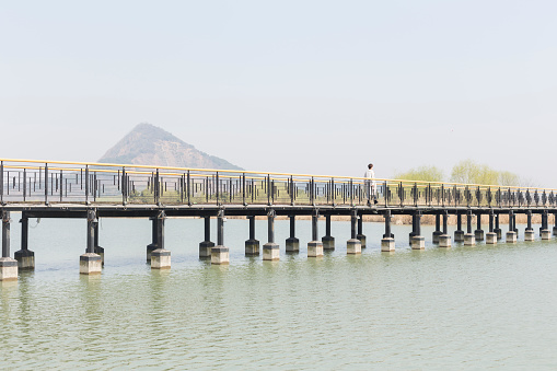 perspective view of young woman walking on bridge at a spring afternoon,china.