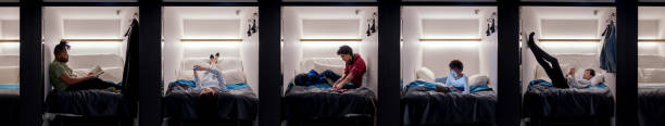 grupo de adultos jóvenes relajantes en un hotel de la cápsula - working bed smart phone bedroom fotografías e imágenes de stock