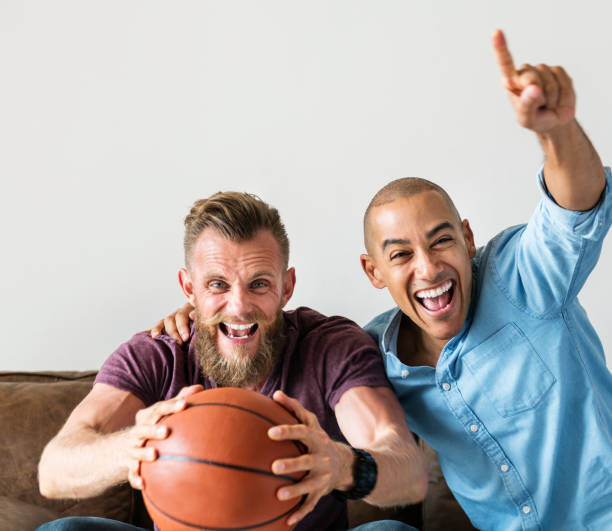 istock Man sitting together on a couch watching sport 935938946