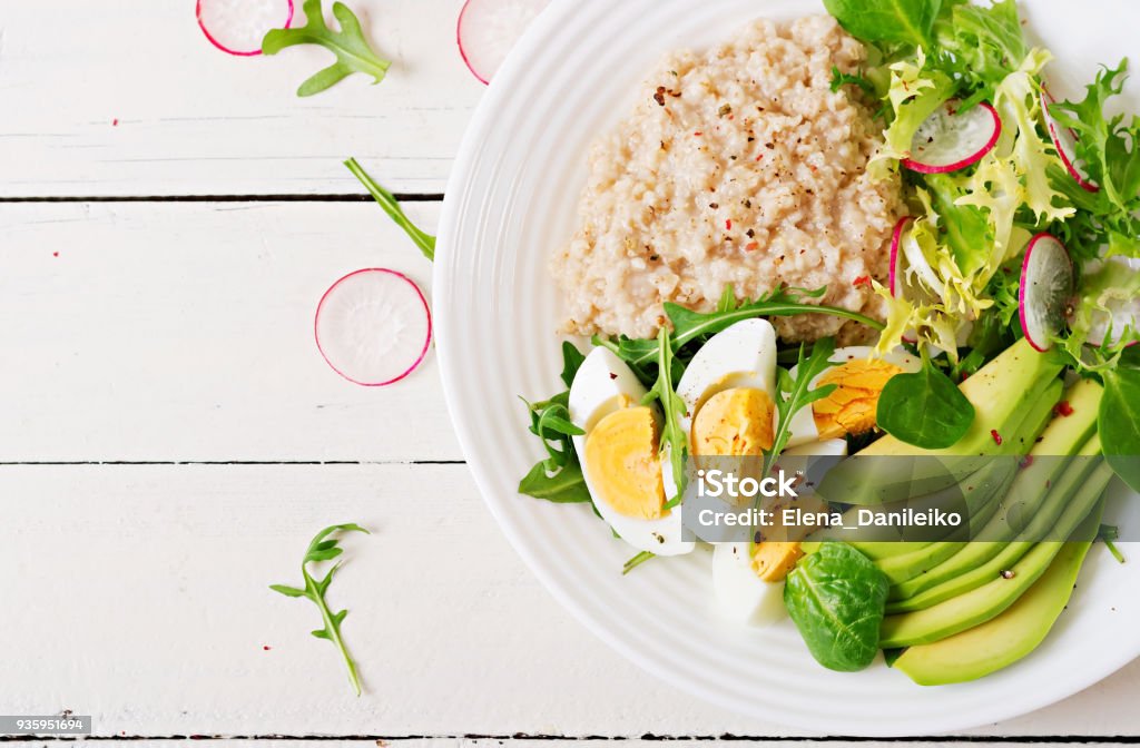 Healthy breakfast. Dietary menu. Oatmeal porridge and avocado salad and eggs. Top view Oatmeal Stock Photo