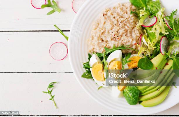 Healthy Breakfast Dietary Menu Oatmeal Porridge And Avocado Salad And Eggs Top View Stock Photo - Download Image Now