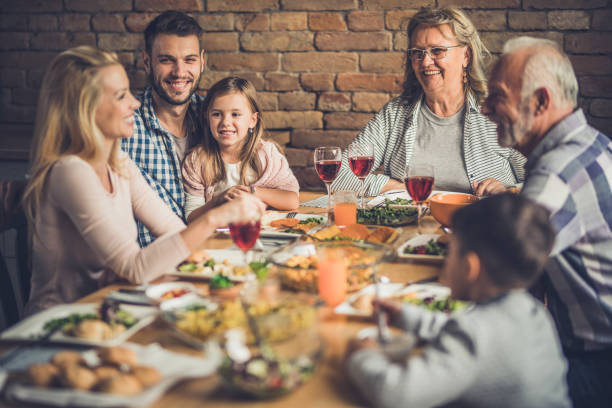 istock Happy multi-generation family enjoying in conversation during lunch at dining table. 935951750