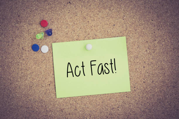 istock Act Fast! written on sticky note pinned on pinboard 935951922