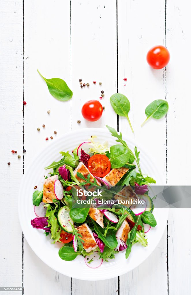 Salat aus frischem Gemüse mit gegrillter Hähnchenbrust - Tomaten, Gurken, Rettich und Mix Salatblätter. Hähnchen-Salat. Gesunde Ernährung. Ansicht von oben - Lizenzfrei Salat - Speisen Stock-Foto