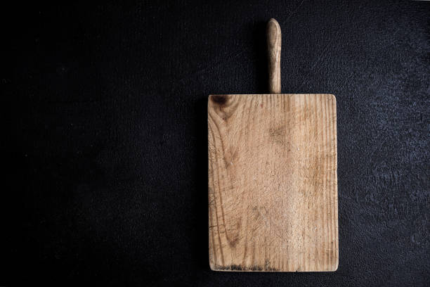 istock Old Chopping cutting board on black chalkboard  background. Empty Textured kitchen desk. Food concept for restaurant menu. Flat lay