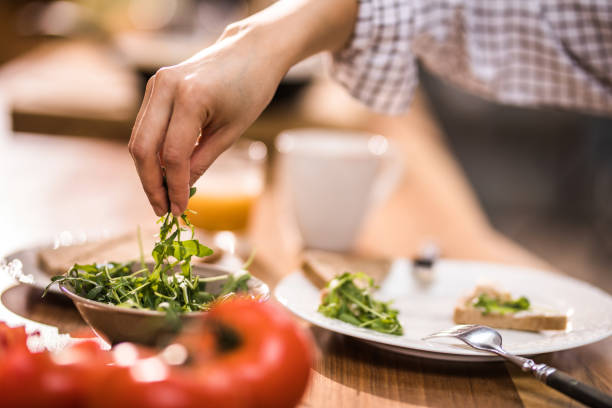 istock Close up of unrecognizable woman taking fresh arugula for breakfast. 935958620
