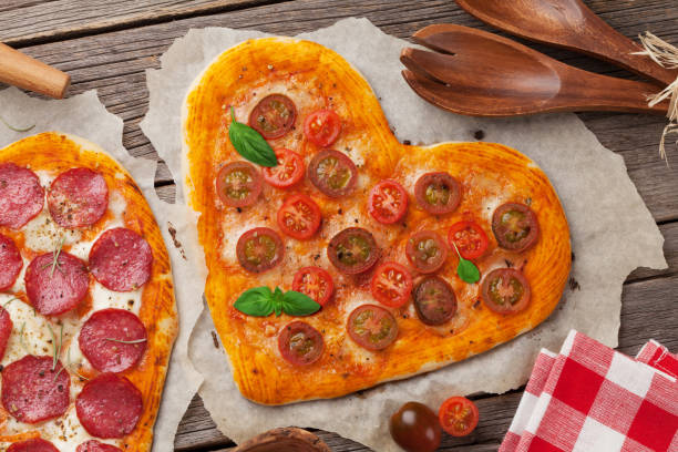 istock Heart shaped pizza with tomatoes and mozzarella 935971590