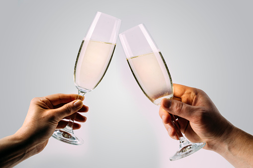 Two hands holding and toasting champagne