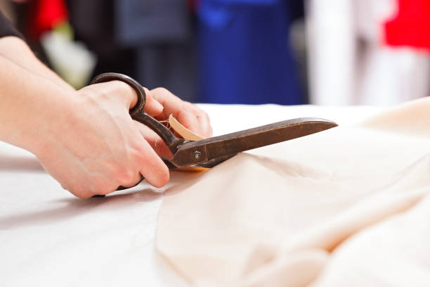 istock Cutting fabric with big old steel scissors 935974766