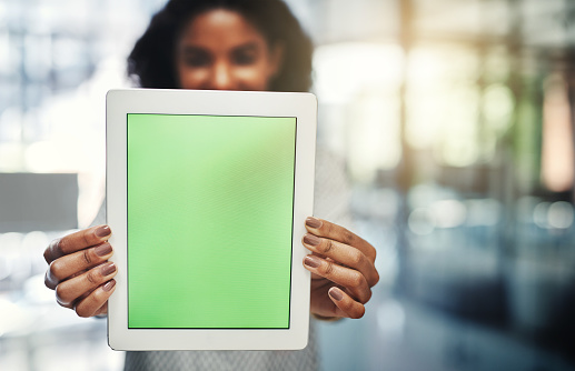 Shot of a young businesswoman holding up a digital tablet with a chroma key screen in an office