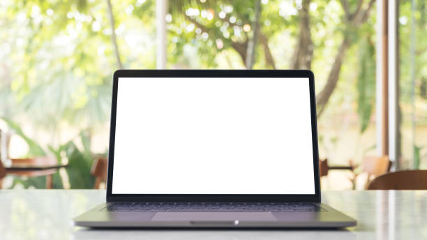 istock Mockup image of laptop with blank white desktop screen on marble table in modern cafe with nature background 935978496