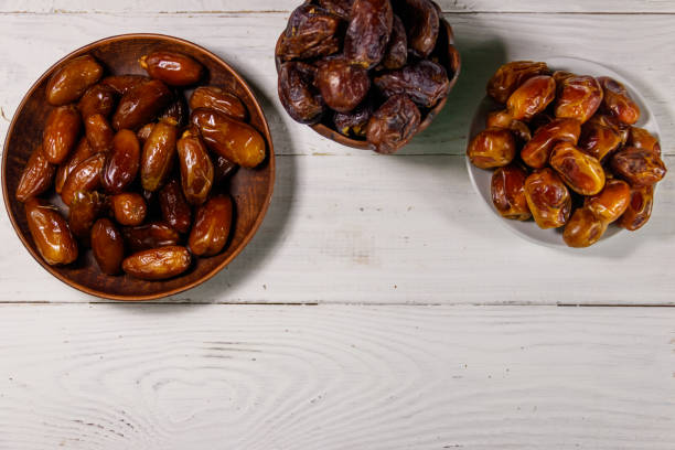 istock Dried dates fruit on white wooden table. Top view 935978910