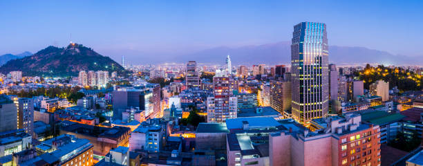 Evening panorama of Santiago de Chile Santiago de Chile dwontown after sunset in a wide panoramic composition, Chile santiago chile photos stock pictures, royalty-free photos & images