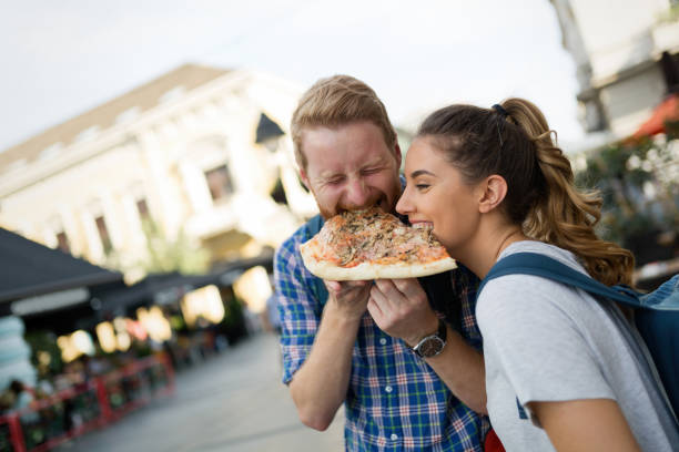 istock Happy couple sharing pizza on street 935982362