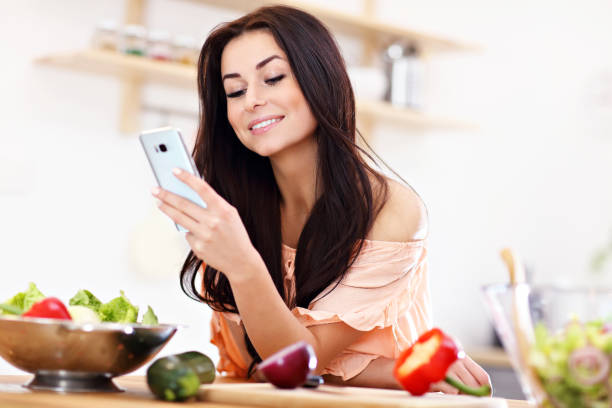 istock Happy woman preparing salad in modern kitchen 935983078