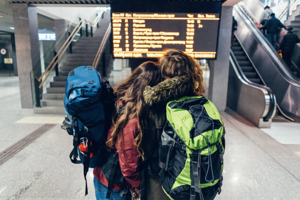 istock Female couple checking the timetable board at the railway station 935986996