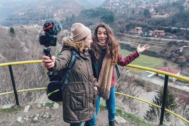 istock Two women making video while standing on high terrace in the rocks 935987008