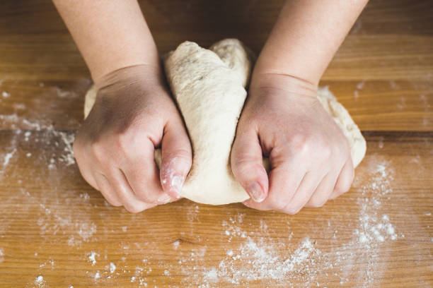 mão de mulher é amassar uma massa para pizza. - bread kneading making human hand - fotografias e filmes do acervo