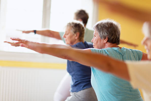 istock active senior women in yoga class warrior pose 935990670