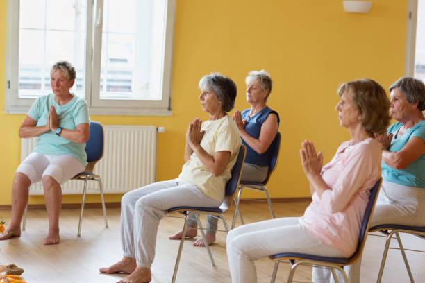 istock active senior women in yoga class exercisig on chairs 935990674