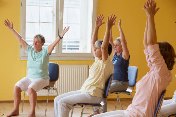 istock active senior women in yoga class exercisig on chairs 935990690